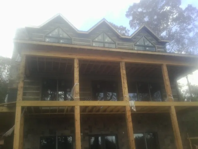 Dormers and porch framing on a large log home under construction — Roof Coating work by our crew in West Brookfield