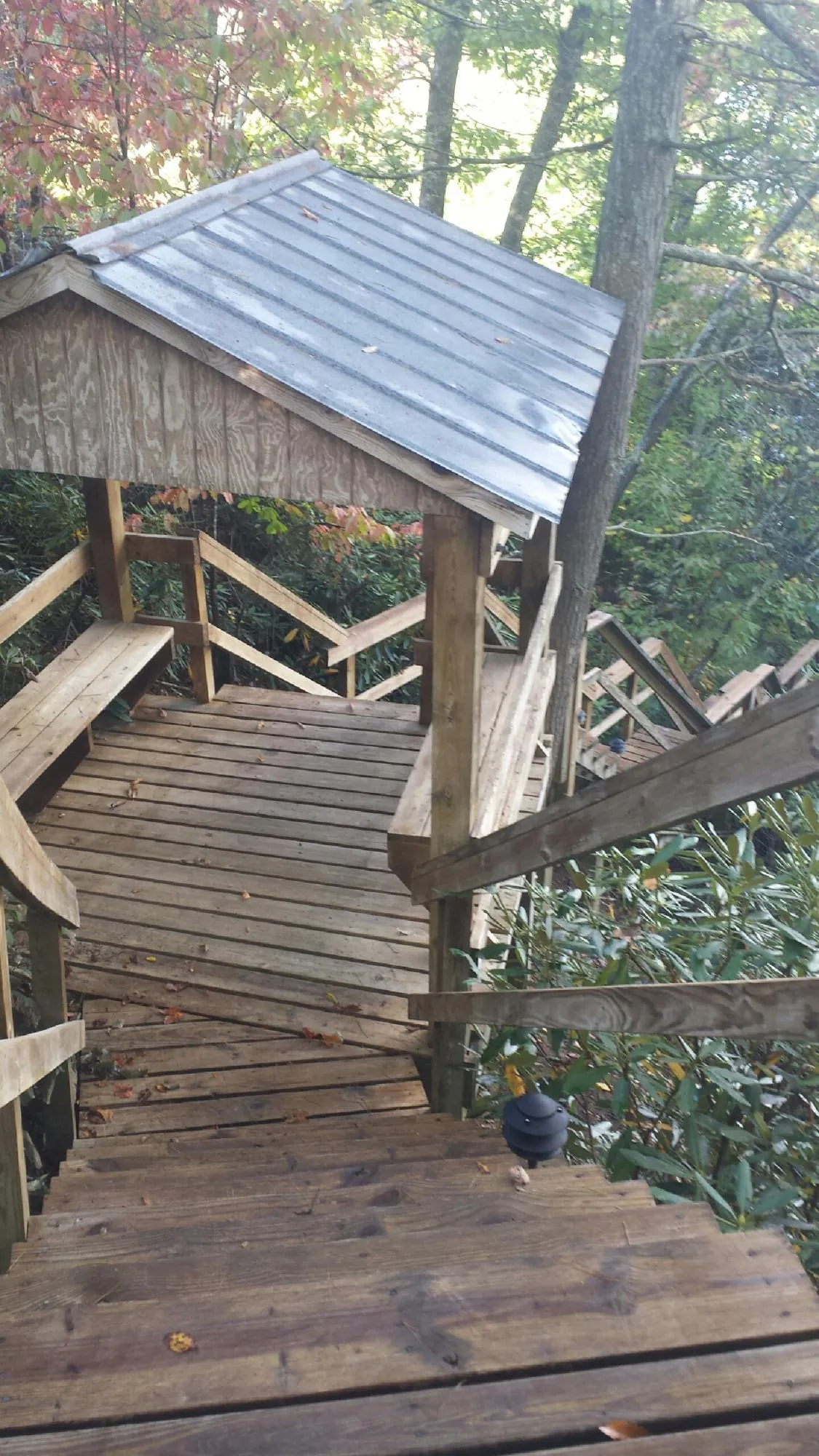 Metal roofed shelter over wooden steps on a wooded walkway — Skylight Repair & Installation work by our crew in West Brookfield