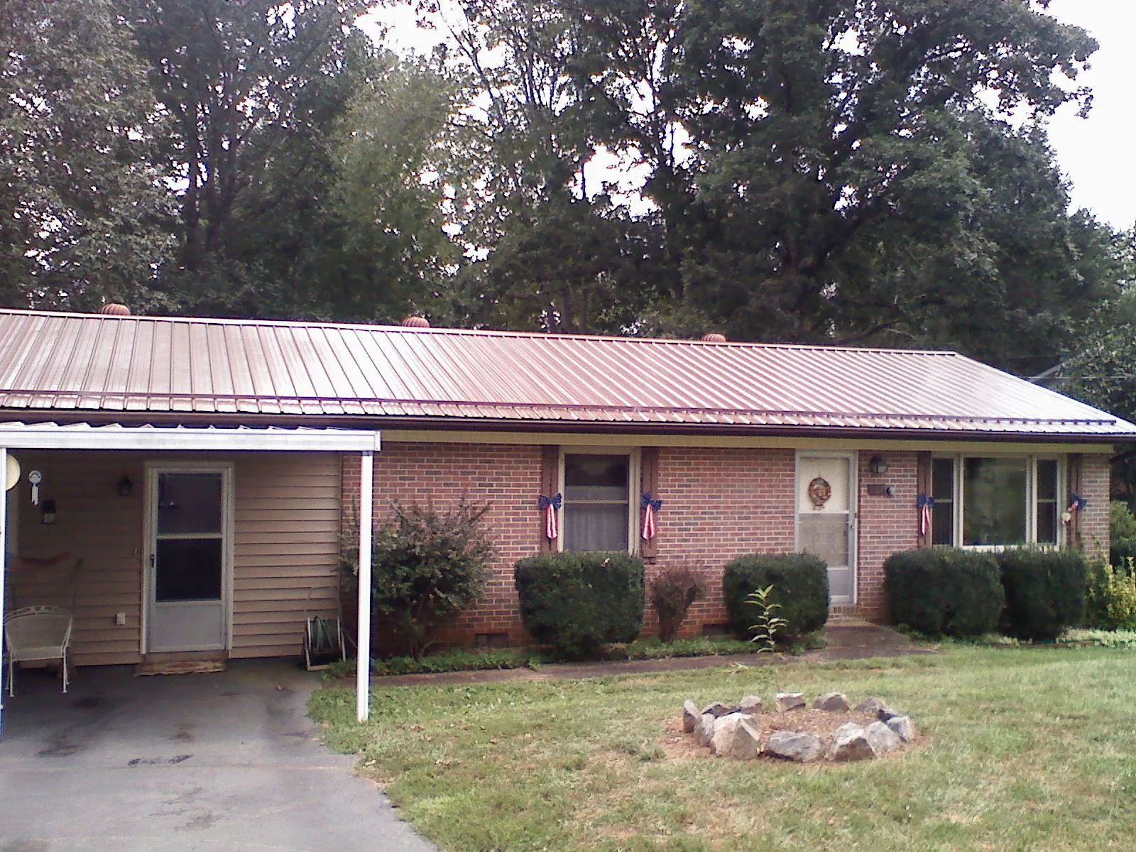 Bronze metal roof and carport on a brick ranch home — Roof Repair work by our crew in West Brookfield
